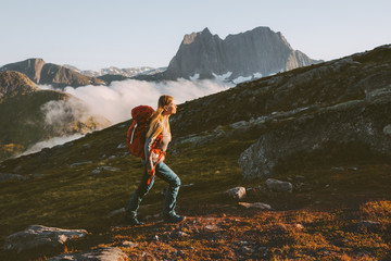 Woman traveler hiking in mountains with backpack adventure travel active healthy lifestyle summer vacations mountaineering in Norway