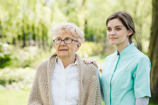 Happy senior woman and helpful caregiver, nursing home concept photos