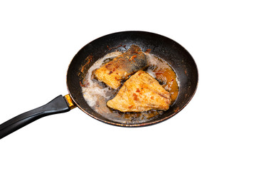 Fried salmon trout fillets in a frying pan in fat, isolated on a white background with a clipping path.