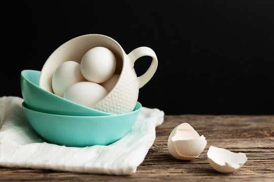Traditional easter food eggs. Colored dishes on a wooden table and black background. Minimalistic design. White napkin and egg shells. Colors Trend 2020