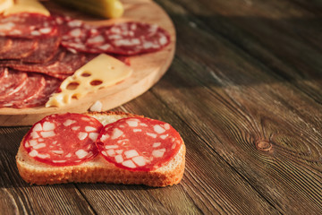 Sausage sandwich and sausage sliced ​​on a wooden board.