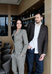 Fashionable adult couple. Man and woman in brown suits. The couple gently embraces.