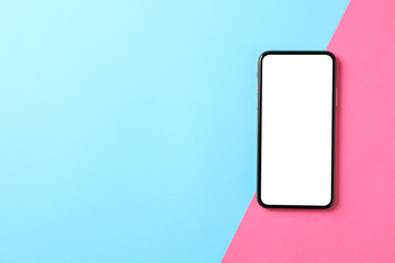 Phone with empty screen on two tone background, top view