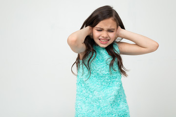 Naklejka premium offended teenage girl in a blue dress indignant on a white studio background