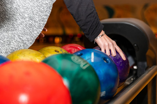 Hand Picking Up Bowling Ball At Bowling Alley.