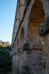 Naklejka premium roman aqueduct tarragona.Roman aqueduct with arches at sunset.Close up of aqueduct
