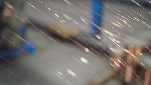 Thin strands of copper wire are woven into a single cable. The process of drawing copper wire at a cable production plant.