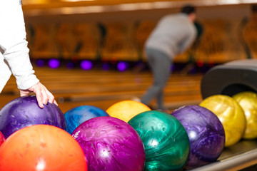 Fototapeta na wymiar Hand picking up bowling ball at bowling alley.