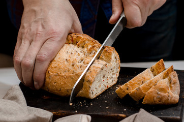 Homemade pastries. Men's hands cut homemade blush bread