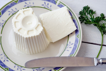 White cheese on plate and rustic wooden table