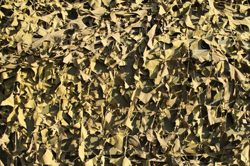 background with camouflage mesh on a sunny day for design on a military theme