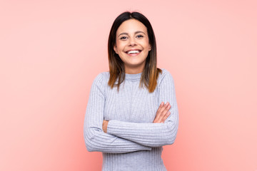 Woman over isolated pink background keeping the arms crossed in frontal position