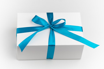 festive white gift box with blue bow