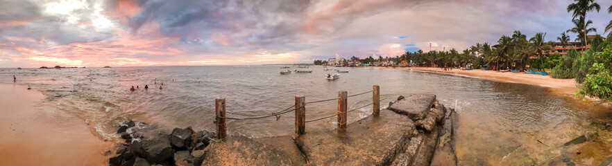 Beautiful panoramic image of old pier on the ocean beach at sunset