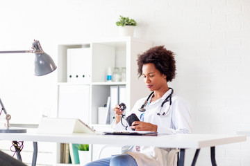 Woman doctor pack blood pressure while wait next patient in ambulance