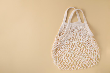 Mesh shopping bag at beige background. Zero waste concept.