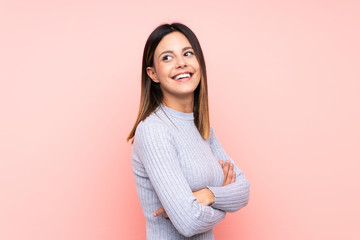 Obraz premium Woman over isolated pink background with arms crossed and happy