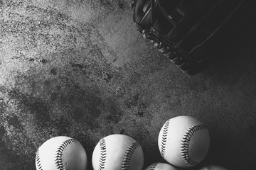 Sports background with baseballs and glove on grunge texture in black and white.