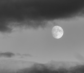 photo of the moon with a thick layer of clouds. moon with clouds
