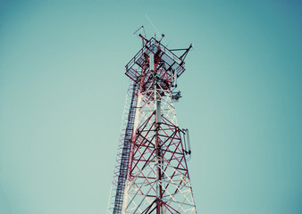 Telecommunication radio signal tower over the blue sky