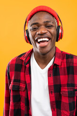 Fototapeta premium handsome smiling black american man listening to music using headphones
