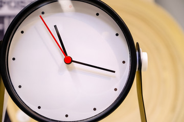 Black clock alarm on a blurred background. Closeup