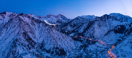 Panorama of the mountains with the road to the ski resort of Chimbulak. Late winter evening