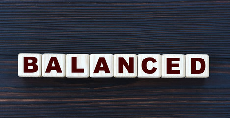 concept word balanced on cubes on a beautiful dark wooden background