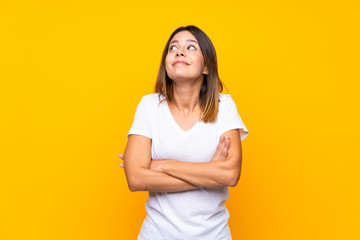 Obraz premium Young woman over isolated yellow background making doubts gesture while lifting the shoulders