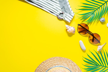 Summer vacation concept. Bright beach accessories on trendy yellow background with copy space for...