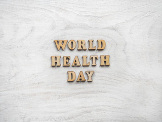 Wooden letters of the alphabet in the form of the words WORLD HEALTH DAY lying on a white table. Beautiful card. Isolated background, wooden surface. Congratulations for relatives, friends, colleagues