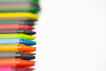 Colourful bright wax pencils isolated on white, close-up selective focus.