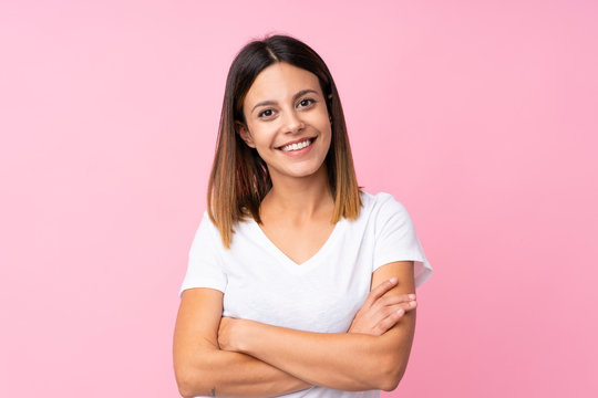 Young woman over isolated pink background keeping the arms crossed in frontal position