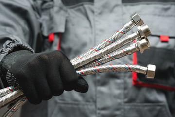 Water hose in plumber hands close up.