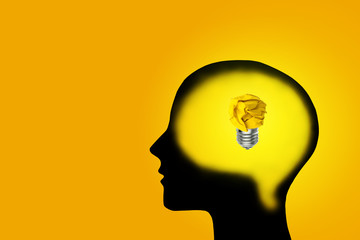 Business Ideas and Creativity Concept : Yellow crumpled paper ball light bulb lighting grow in brain.