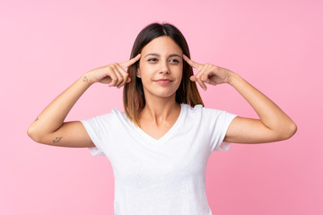 Young woman over isolated pink background having doubts and thinking