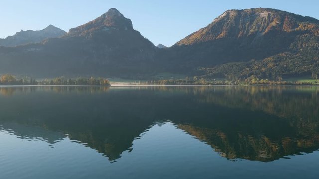 Peaceful autumn Alps mountain lake. Hazy morning Wolfgangsee lake view, St. Wolfgang im Salzkammergut, Upper Austria.