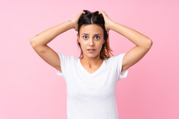 Fototapeta premium Young woman over isolated pink background frustrated and takes hands on head