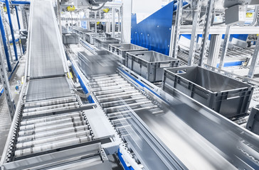 Modern conveyor system with boxes in motion, shallow depth of field. - 324628680