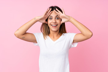 Fototapeta premium Young woman over isolated pink background with surprise expression