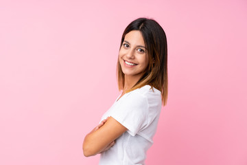 Fototapeta premium Young woman over isolated pink background with arms crossed and looking forward