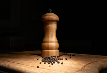 Poivrier et  grains de poivre sur un planche en bois 
