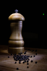 Poivrier et  grains de poivre sur un planche en bois 