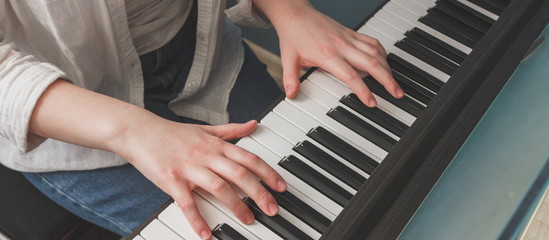 Teenage girl generation in headphones plays the piano, synthesizer, composes music, teenagers'...