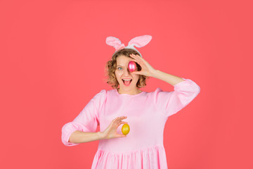 Happy Easter. Egg hunt. Girl holds color egg. Spring holiday. Smiling woman in rabbit bunny ears. Woman preparing for Easter. Hunts for Easter eggs. Easter celebration concept.