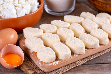 Fototapeta na wymiar Dumplings from cottage cheese. Lazy dumplings close-up on a cutting board.