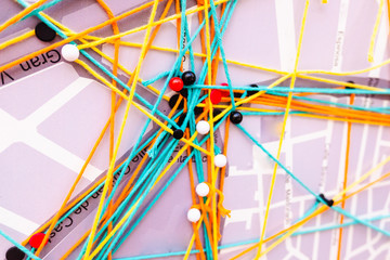 Network connections on a city map made with pins and threads.