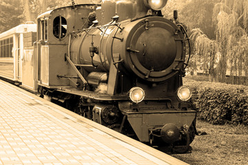 Old steam locomotive. Old vintage steam-powered train rides on rails.