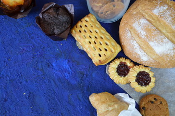 Different kinds of bread rolls on black board from above. Kitchen or bakery poster design. muffin,...