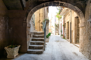 Fototapeta na wymiar An ancient vaulted backalley in southern Italy, leading to a row of private houses